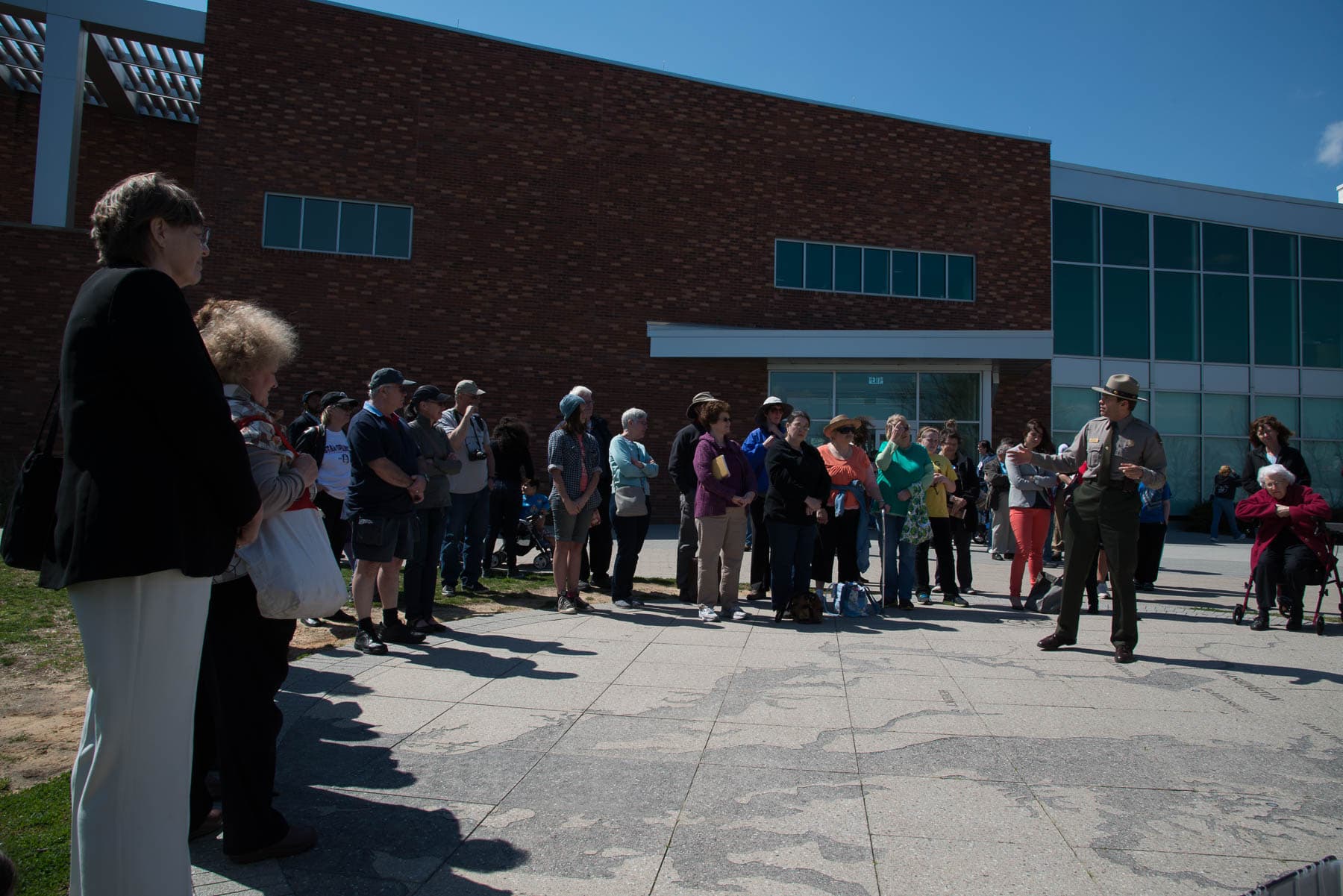A ranger speaks to a crowd outside the Fort McHenry visitor center.
