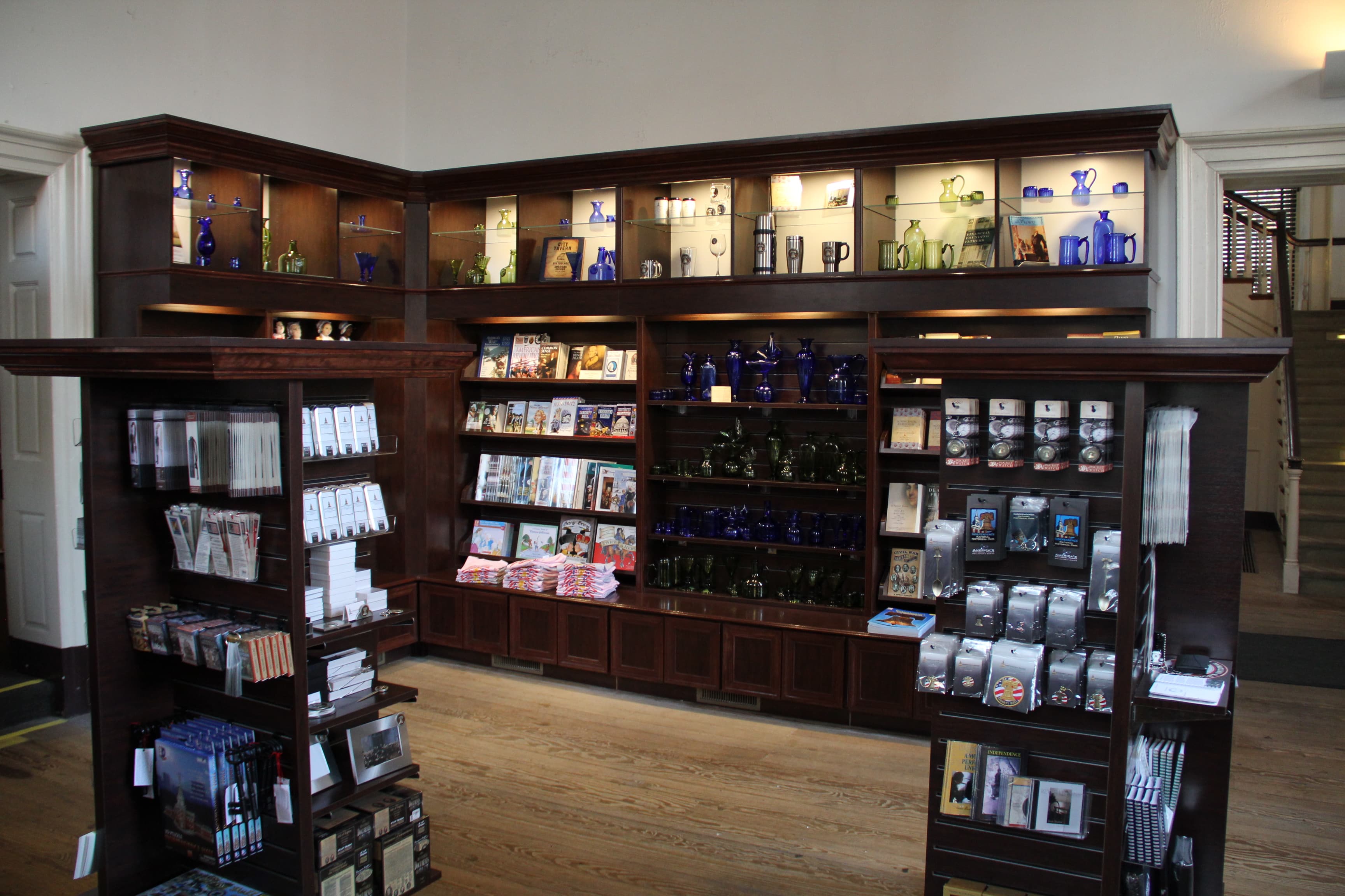 Interior view of a store featuring souvenirs on wall mounted and freestanding display cases.
