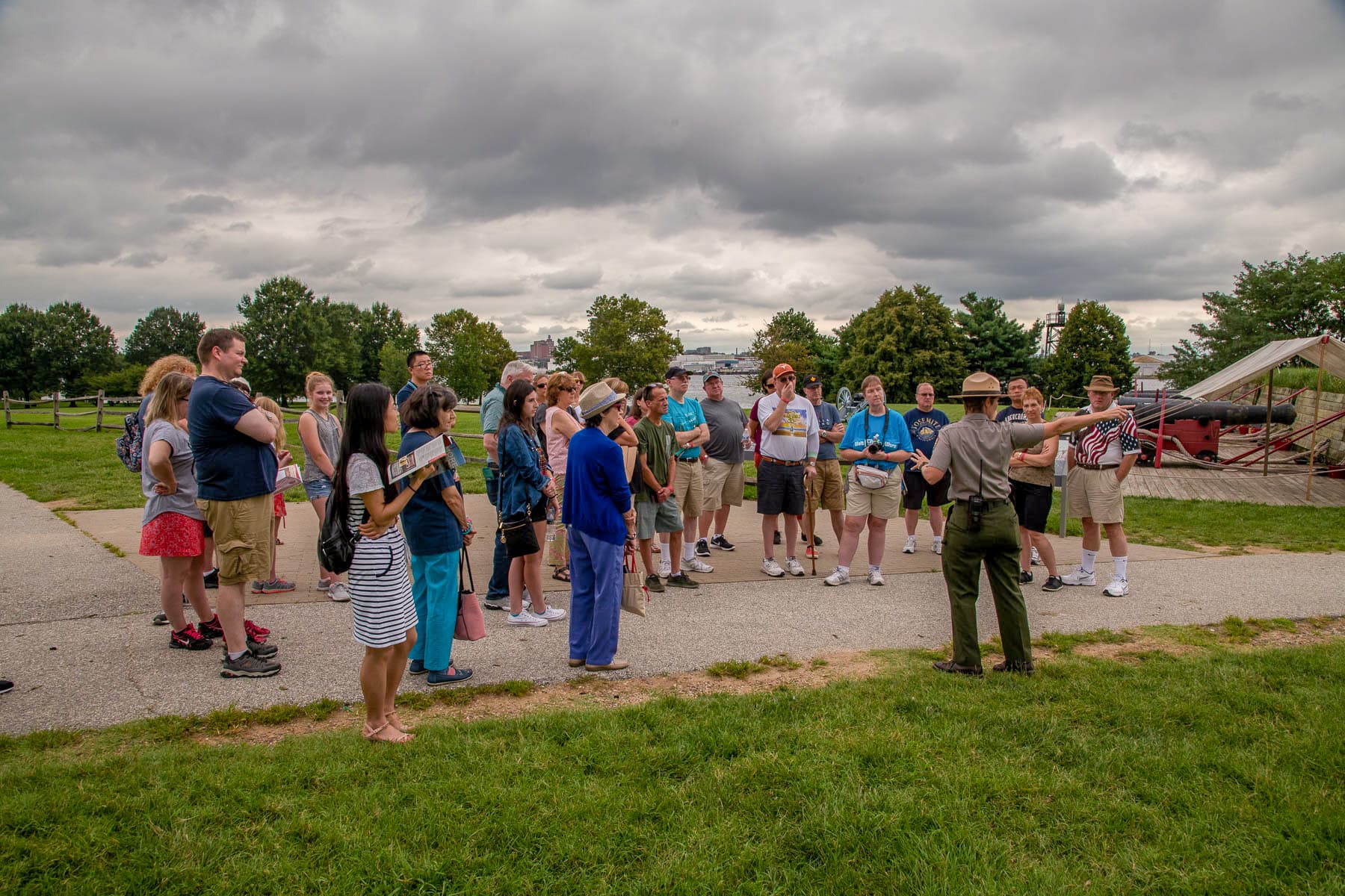 Ranger pointing toward river with cannons in background