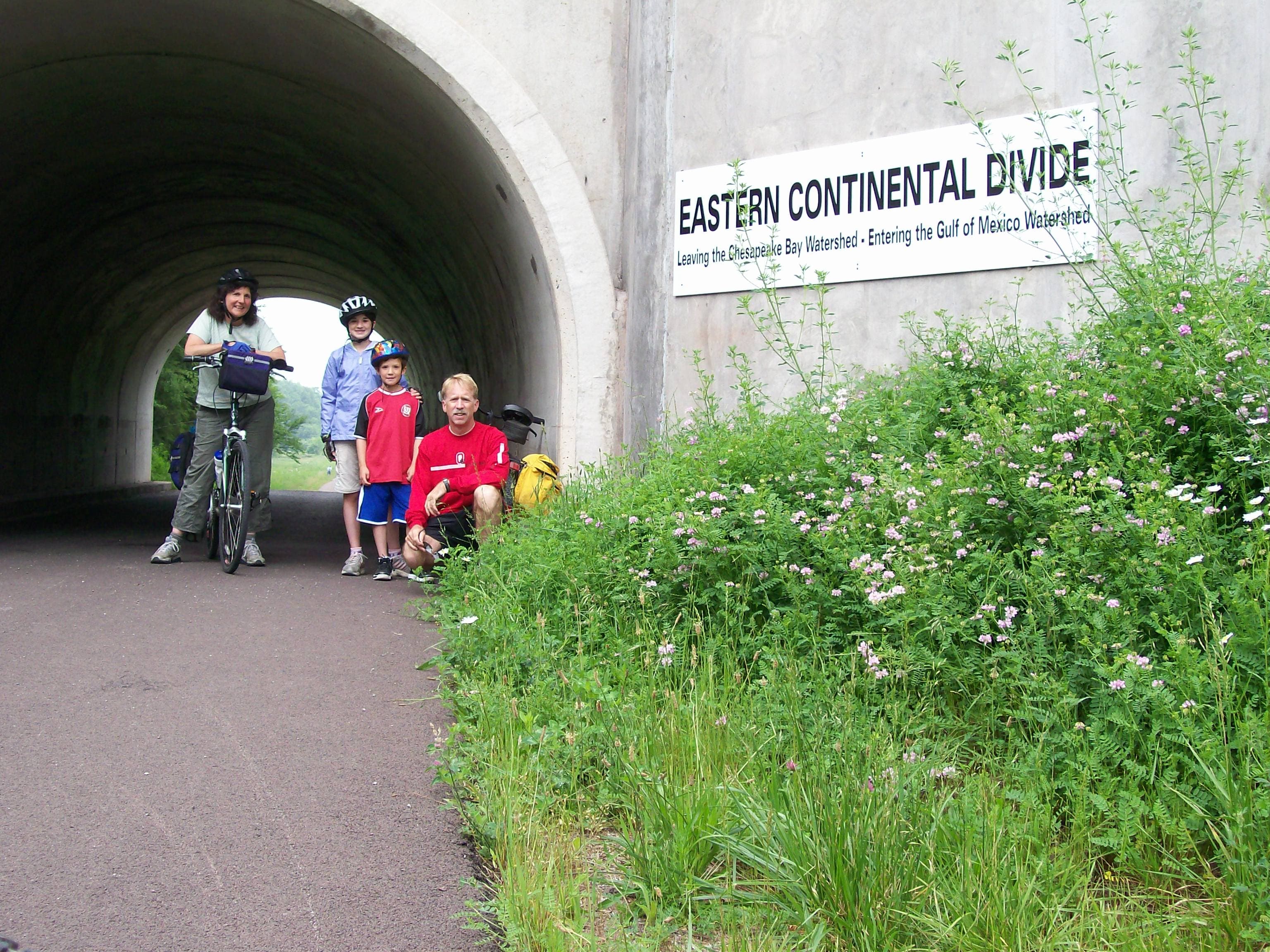 family of bicyclists at the Eastern Continental Divide on the Great Allegheny Passage rail-trail