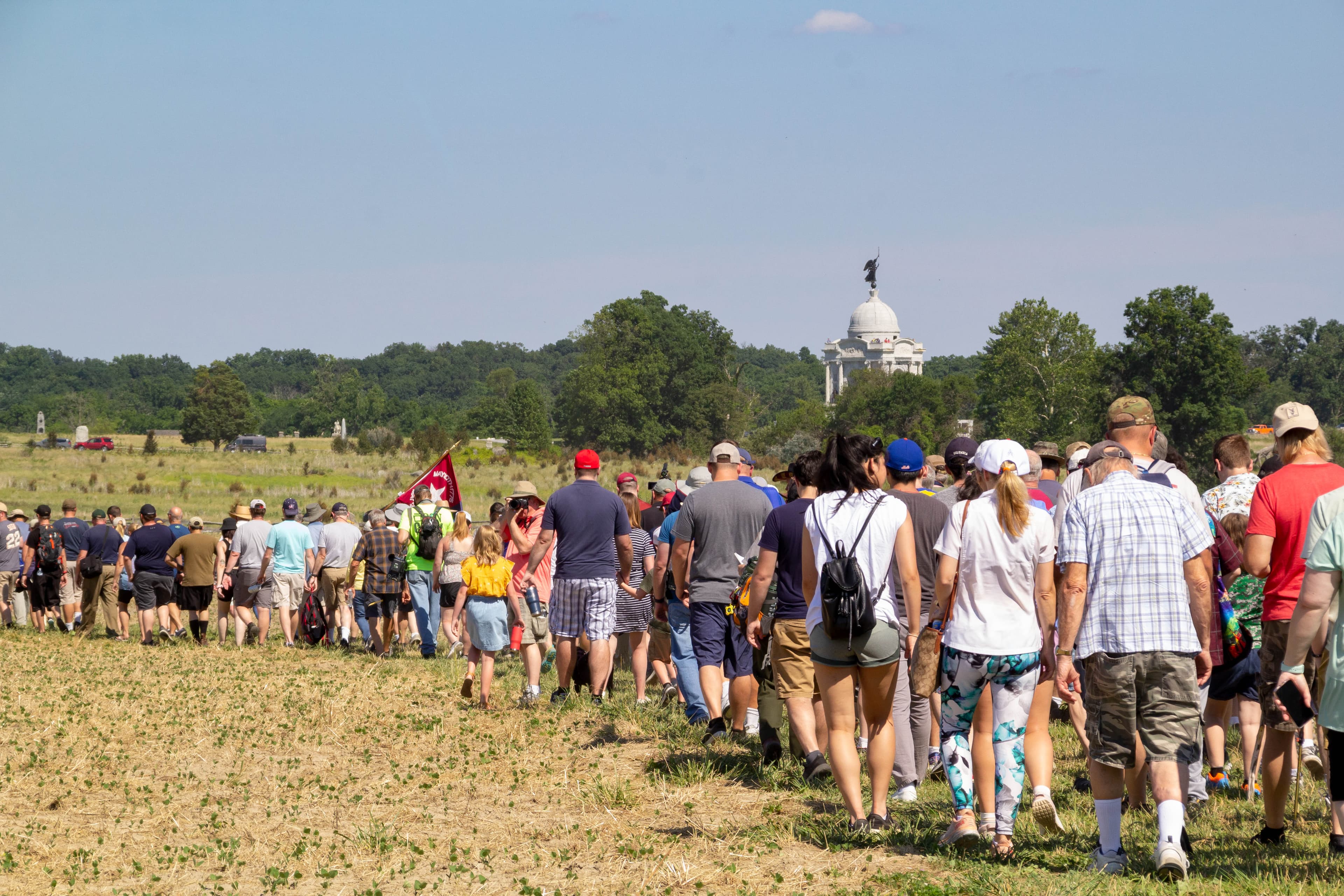 A large group of 200 people hike on a field.