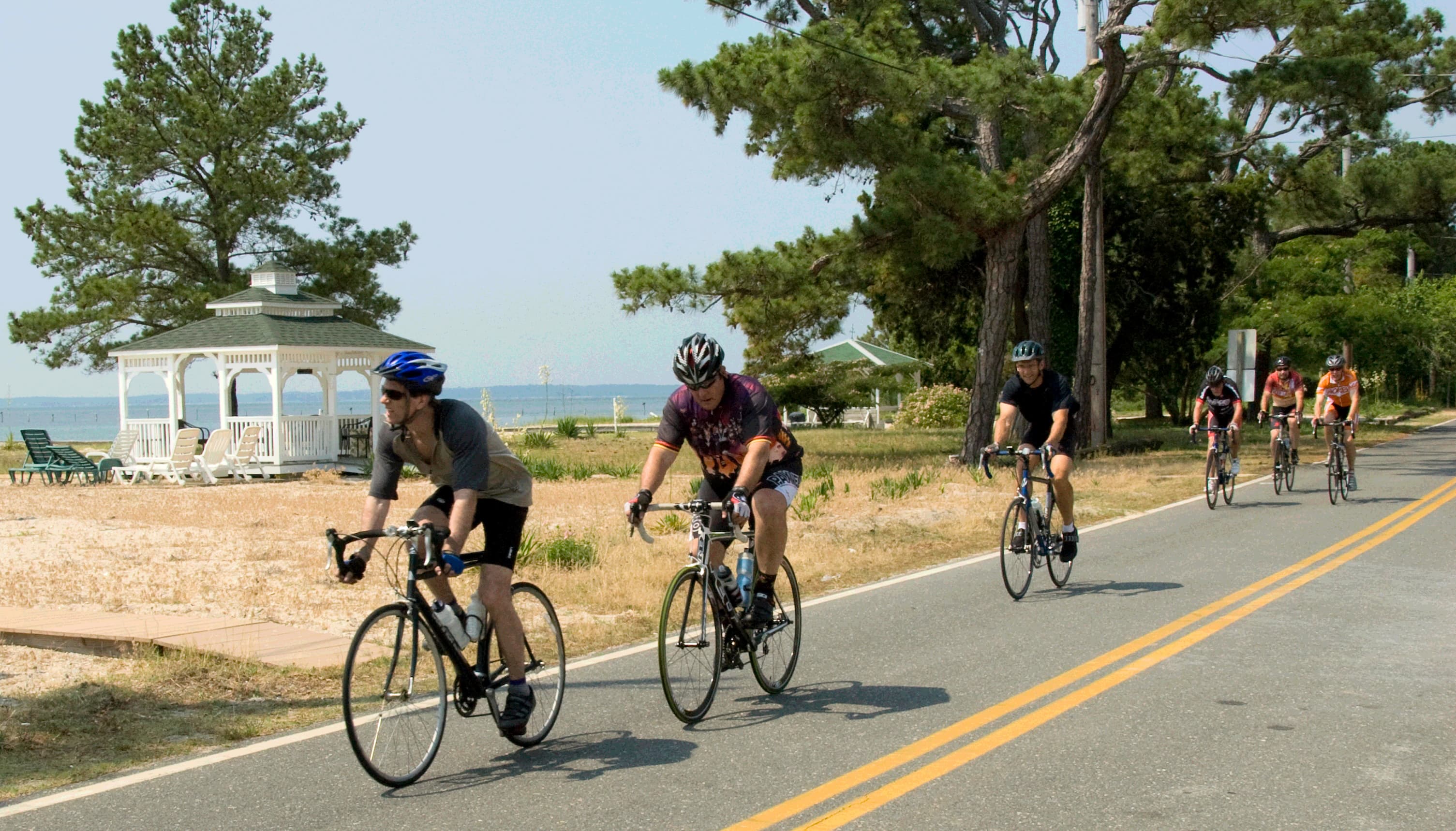 group of bicyclists on a road in Southern Maryland with a glimpse of the Potomac River