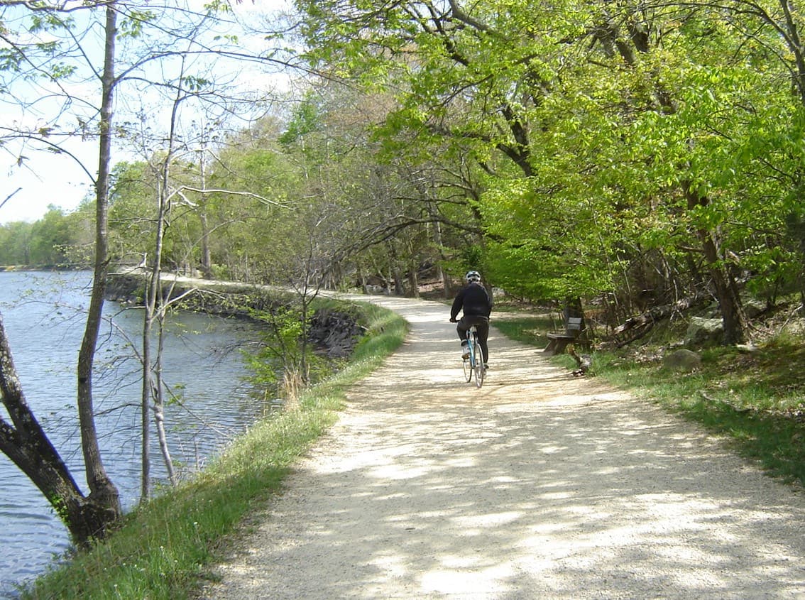 A single bike rider on the towpath next to the widewater section of the canal.